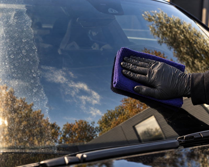THE COLLECTION "Waffle" glass cloth drying the clear windscreen next to the last limescale spots — shown in the article “Removing limescale spots from car windows without scratching the glass”